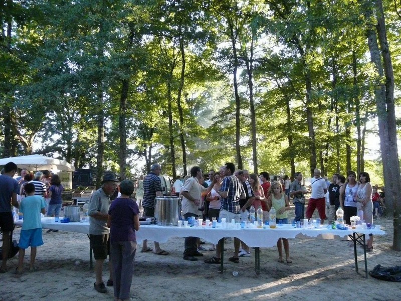 Des personnes partagent l'apéritif au milieu des arbres.